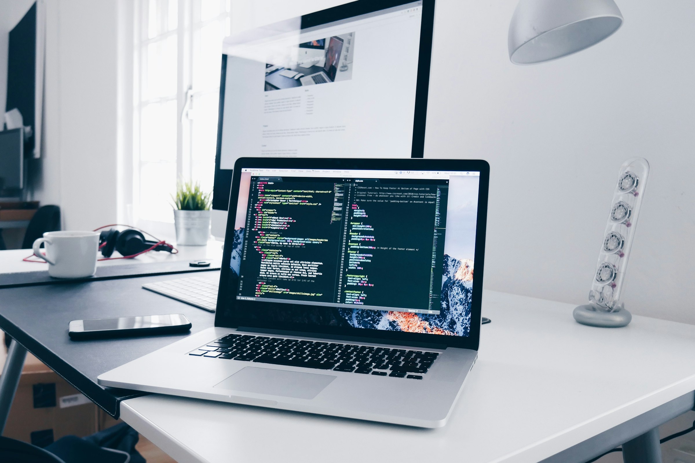 Escritorio de desarrollo con laptop y código en pantalla